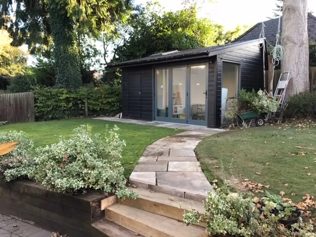 Garden office with pathway leading up to it.