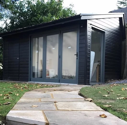 Black outdor building with pathway.