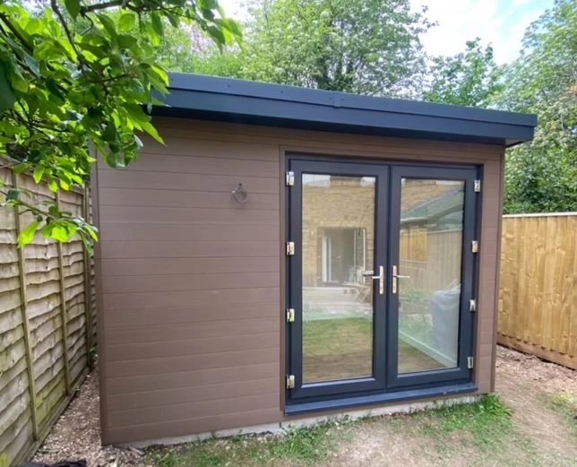 Brown outdoor building with black door frame.